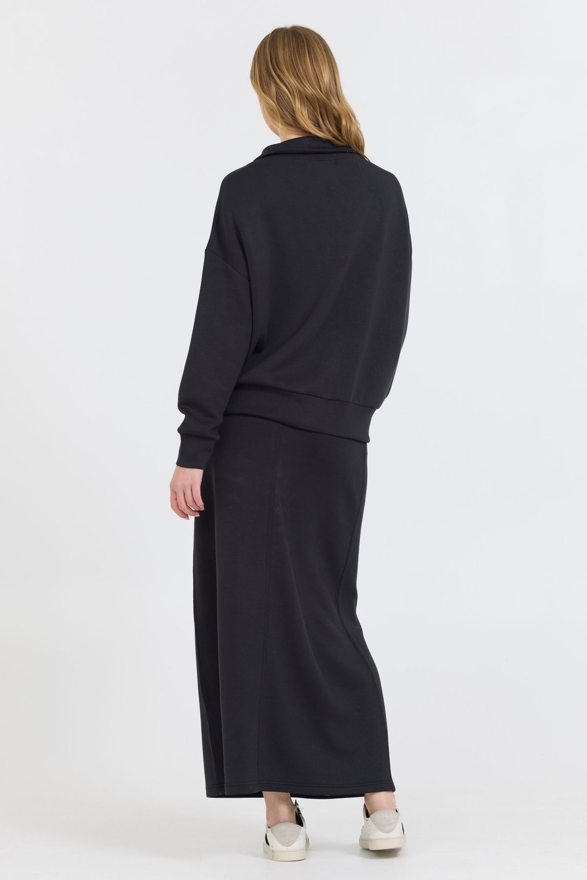 Constructed with a blend of 49% Modal, 45% Polyester, and 6% Spandex, the Black Cloud Fleece Maxi Skirt boasts an ankle-length design that adds a slimming touch to your cozy ensemble.