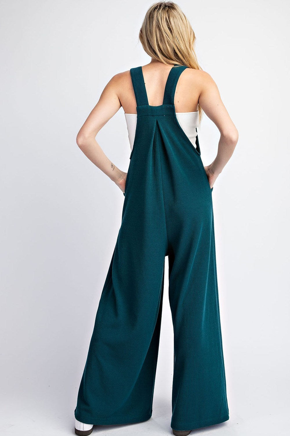 This Solid Sleeveless Wide Leg Jumpsuit boasts a square neckline, button adjustable straps, and a front bib pocket. The added pleats provide intricate detailing and there are also two side hip pockets. Made with 93% polyester and 7% spandex for a comfortable, stylish fit.