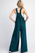 This Solid Sleeveless Wide Leg Jumpsuit boasts a square neckline, button adjustable straps, and a front bib pocket. The added pleats provide intricate detailing and there are also two side hip pockets. Made with 93% polyester and 7% spandex for a comfortable, stylish fit.