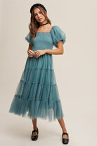 This Sagebrush colored Puff Sleeve Smocked Mesh Maxi Dress features a square neck, ruffle detail, and elastic for a comfortable and stylish fit. The smocked bodice and puff sleeves add texture and dimension, while the tiered skirt and raw edge provide a unique finish. Made of 100% Polyester, this dress is fully lined for ultimate comfort and quality.