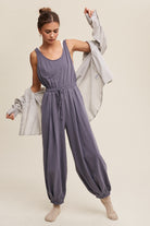 This Tank and Jogger Pants Open Back Knit Jumpsuit features a round neck, elastic shoulder strap, drawstring waist with tie string, and pockets on the pants. Made from 100% cotton in a charcoal color, the jumpsuit is finished with an elastic hem for a comfortable and stylish fit.