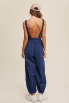 Crafted from 100% cotton, this Navy Tank and Jogger Pants Open Back Knit Jumpsuit features a round neck, elastic shoulder strap, drawstring waist with tie string, and convenient pockets on the pants. The elastic hem adds a finishing touch to this versatile, comfortable and stylish piece.