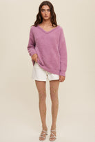 The Deep V-Neck Peal Detail Fuzzy Knit Sweater is composed of a soft touch Fuzzy Knit material, featuring a deep V-neckline and delicate pearl detailing. It boasts long sleeves and is finished with ribbed accents on the neck, cuffs and hem. Made of 65% acrylic and 35% polyester, this sweater is available in a lovely Lilac hue.