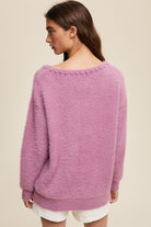 The Deep V-Neck Peal Detail Fuzzy Knit Sweater is composed of a soft touch Fuzzy Knit material, featuring a deep V-neckline and delicate pearl detailing. It boasts long sleeves and is finished with ribbed accents on the neck, cuffs and hem. Made of 65% acrylic and 35% polyester, this sweater is available in a lovely Lilac hue.