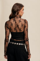 This Lace Mock Neck Long Sleeve Layering Top features a light weight sheer fabrication with mesh embroidery, offering a sophisticated and elegant look. The top also includes a mock neck and long sleeves, and is made with 90% Nylon and 10% Spandex for a comfortable and stretchy fit. It is available in black.