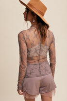 This Lace Mock Neck Long Sleeve Layering Top features a lightweight sheer fabrication that is 90% Nylon and 10% Spandex, with a stylish mesh embroidery lace design. It also includes a mock neck and long sleeves, making it a versatile and fashionable addition to any wardrobe. Available in the color grey.