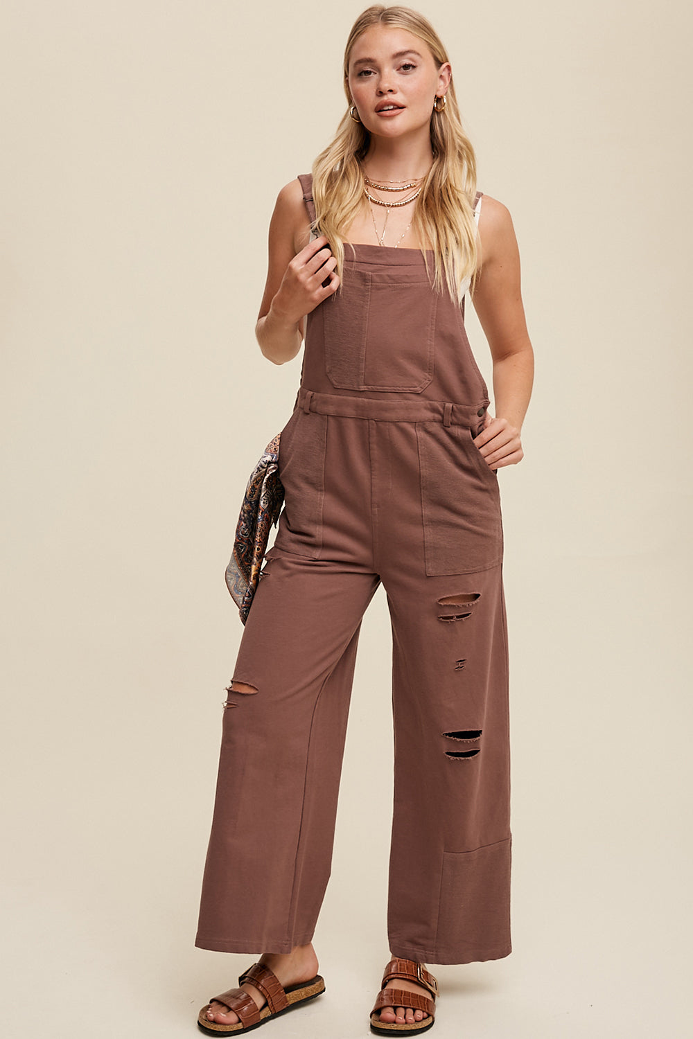 Crafted from 100% cotton, the Distressed French Terry Overalls feature a relaxed fit with distressed detailing, adjustable straps with buckle closures, and a convenient front pouch pocket. Complete with a waistband and belt loop, low back drop, and patch detailing on the bottom pants, this versatile piece is finished with a clean hem. Available in Mocha.