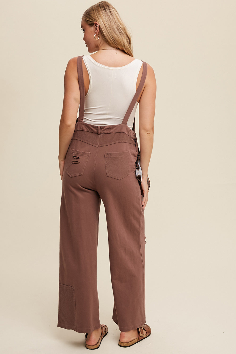 Crafted from 100% cotton, the Distressed French Terry Overalls feature a relaxed fit with distressed detailing, adjustable straps with buckle closures, and a convenient front pouch pocket. Complete with a waistband and belt loop, low back drop, and patch detailing on the bottom pants, this versatile piece is finished with a clean hem. Available in Mocha.