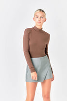 The Turtle Neck Top offers a snug bodice and long sleeves, ideal for colder temperatures. The turtleneck adds extra coverage and warmth while the stretchy knit fabric allows for comfortable movement. This top is a must-have for chilly weather. Expertly crafted with a fitted bodice, long sleeves, and a knit design, it is easily washed and maintained. The fabric composition of 95% Rayon and 5% Spandex guarantees durability and comfort.