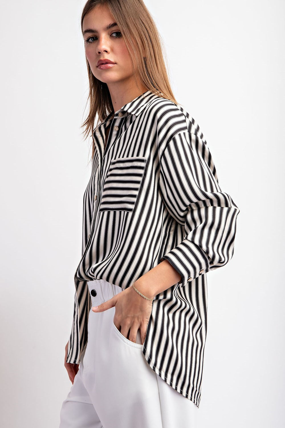 This cropped-length top is made from 100% polyester and boasts a collared neckline, button-down front, and two chest pockets. It also features a bottom hem tie closure and buttoned cuffs for a sophisticated touch.