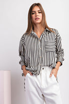 This cropped-length top is made from 100% polyester and boasts a collared neckline, button-down front, and two chest pockets. It also features a bottom hem tie closure and buttoned cuffs for a sophisticated touch.