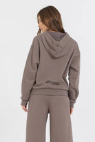 The Taupe Grey Fleece Hoodie with Flocking Detail is made of a blend of 49% Modal, 45% Polyester, and 6% Spandex. This unique fabric combination provides a comfortable and durable hoodie with a stylish flocking detail on the hood.