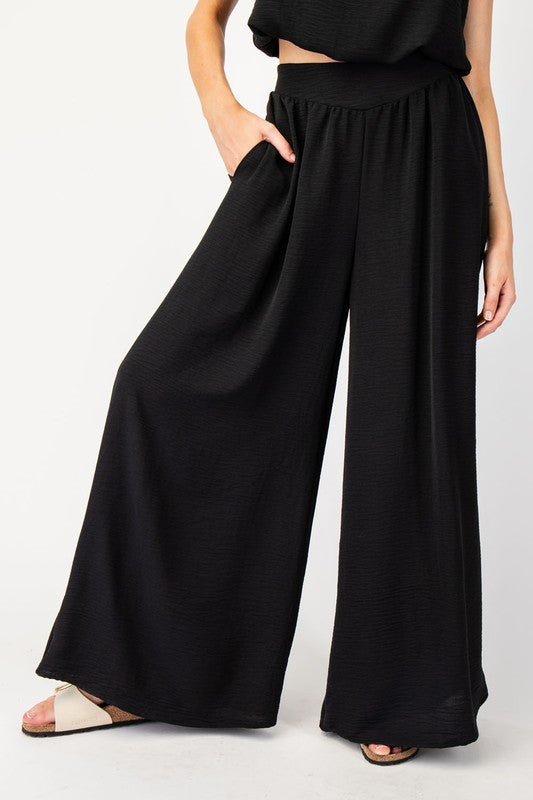 Expertly designed with a 100% polyester construction, these solid wide leg pants offer ultimate comfort with an added elastic band at the back. Complete with two side hip pockets and a pinched design, these pants are perfect for any occasion.